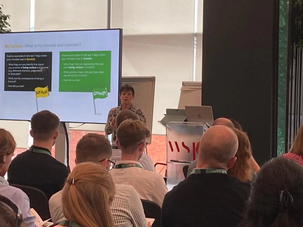 Jackie Grier presenting on survival and growth mindset to a seated audience